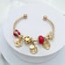 Linx Yellow Gold Open Bangle with Red and Gold Themed Charms
