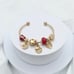Linx Yellow Gold Open Bangle with Red and Gold Themed Charms