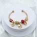 Linx Yellow Gold Open Bangle with Red and Gold Themed Charms