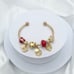Linx Yellow Gold Open Bangle with Red and Gold Themed Charms