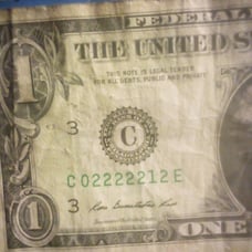 A one dollar bill with the numbers 02222212
