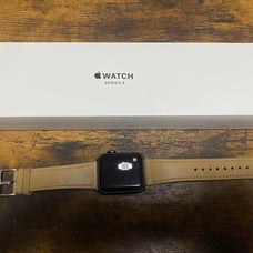 Apple Watch Series 3 with a beige band.