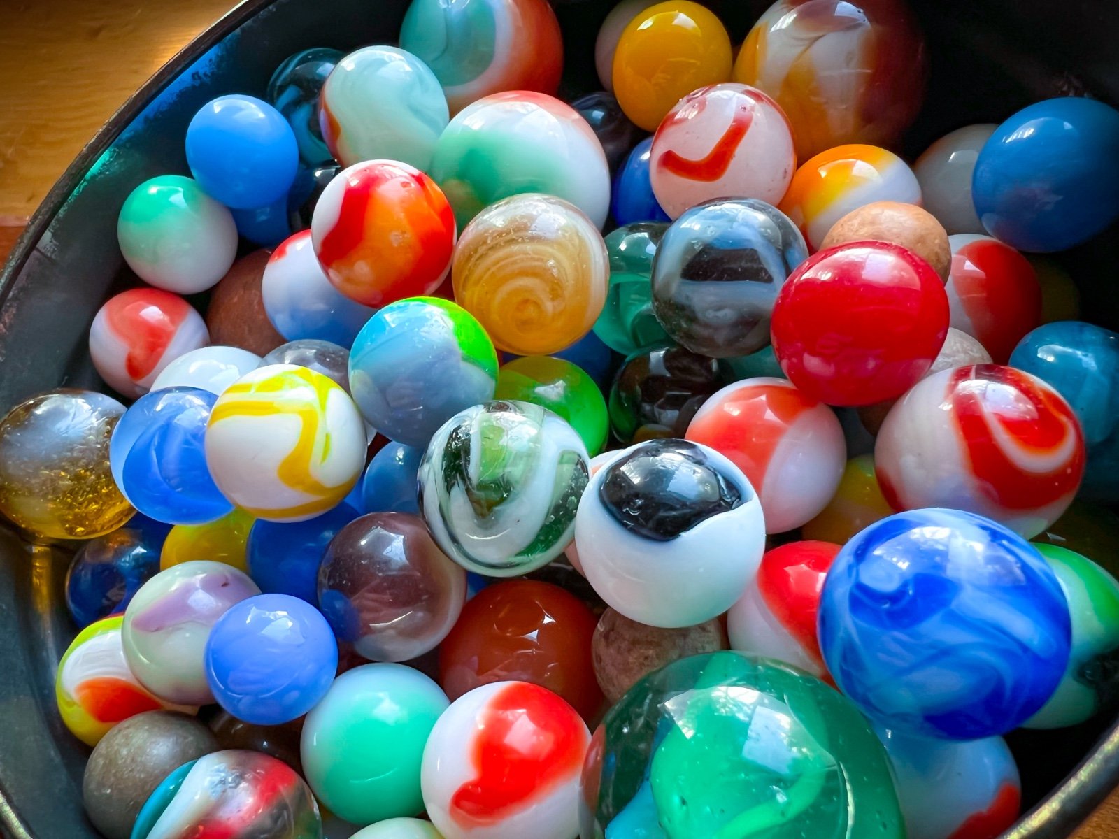 vintage antique old collectible glass toy marbles in an old tin
