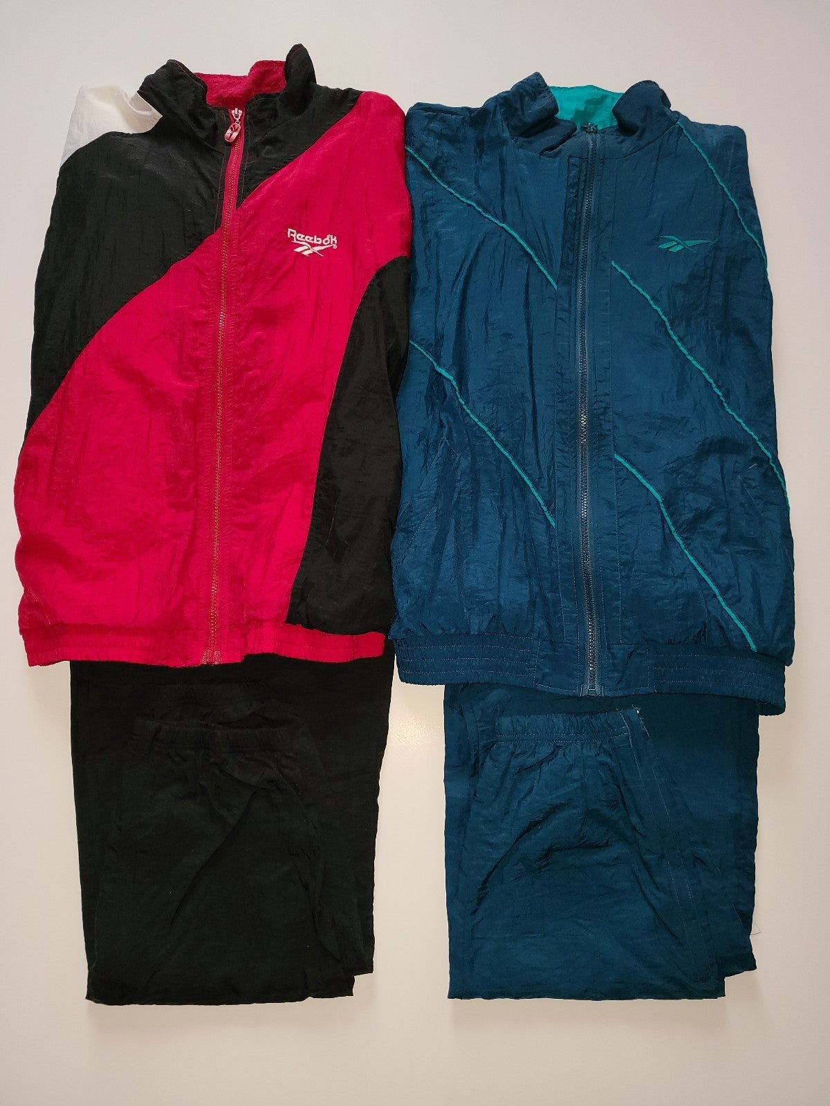 Two Reebok tracksuits. One is green and one is red and black. Size is XL.