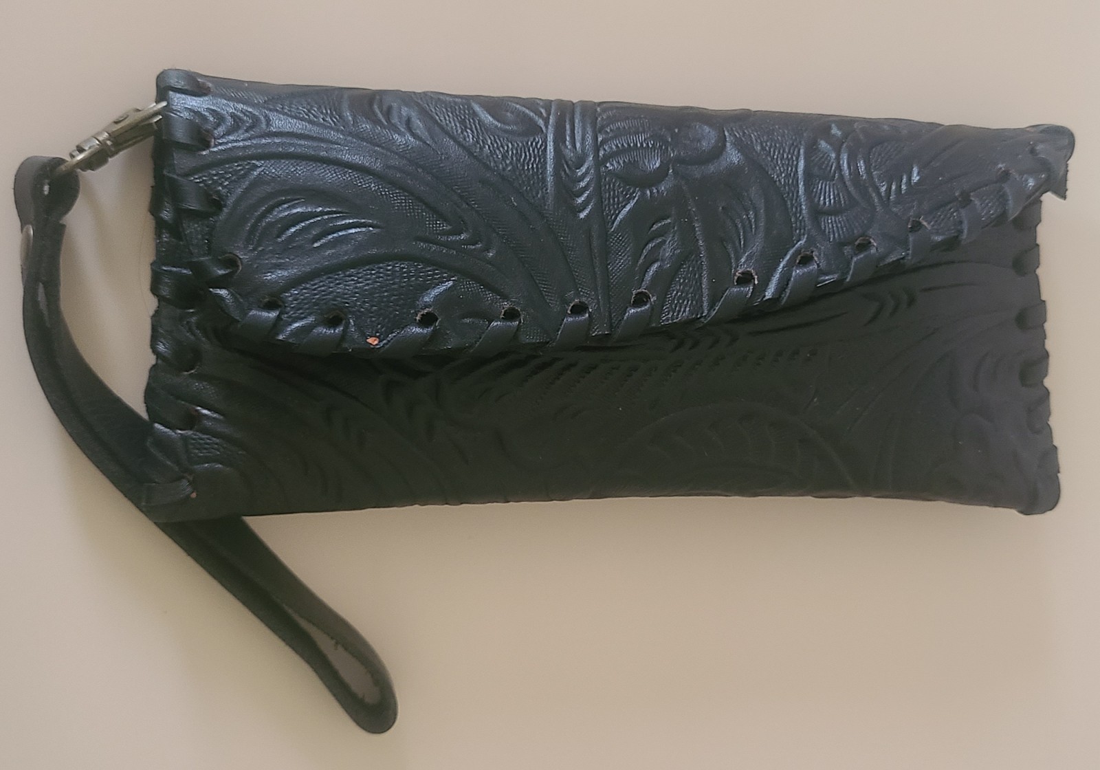 Tooled black leather wristlet.