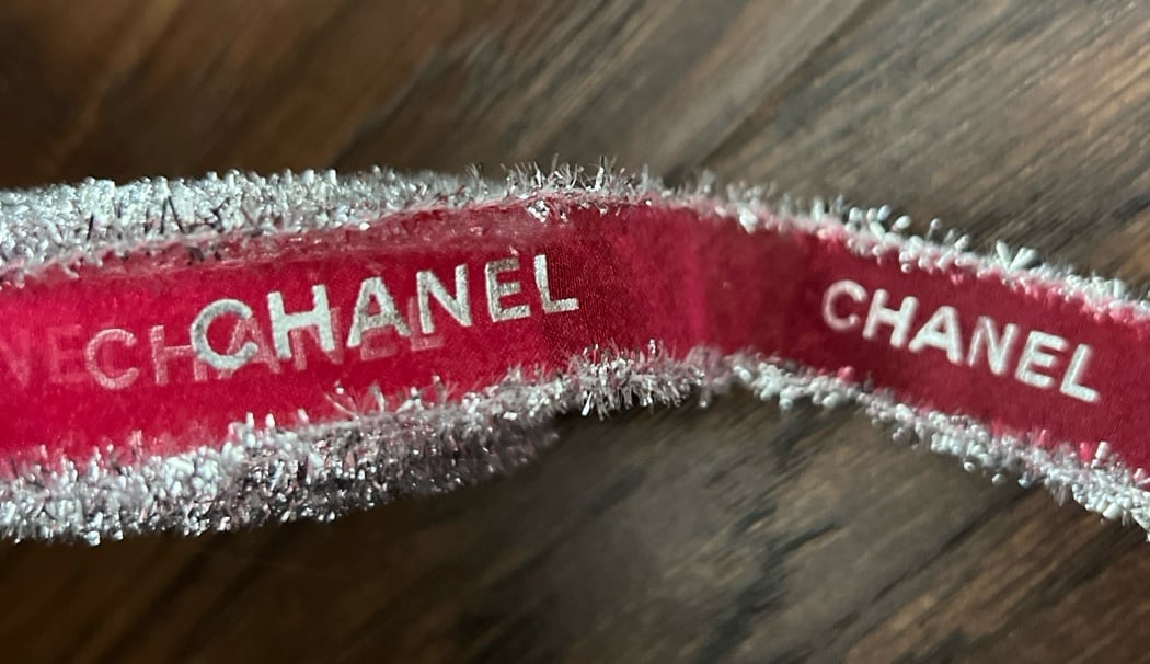 Chanel ribbon. Used for in store wrapping of Chanel gifts. Sheer red with silver