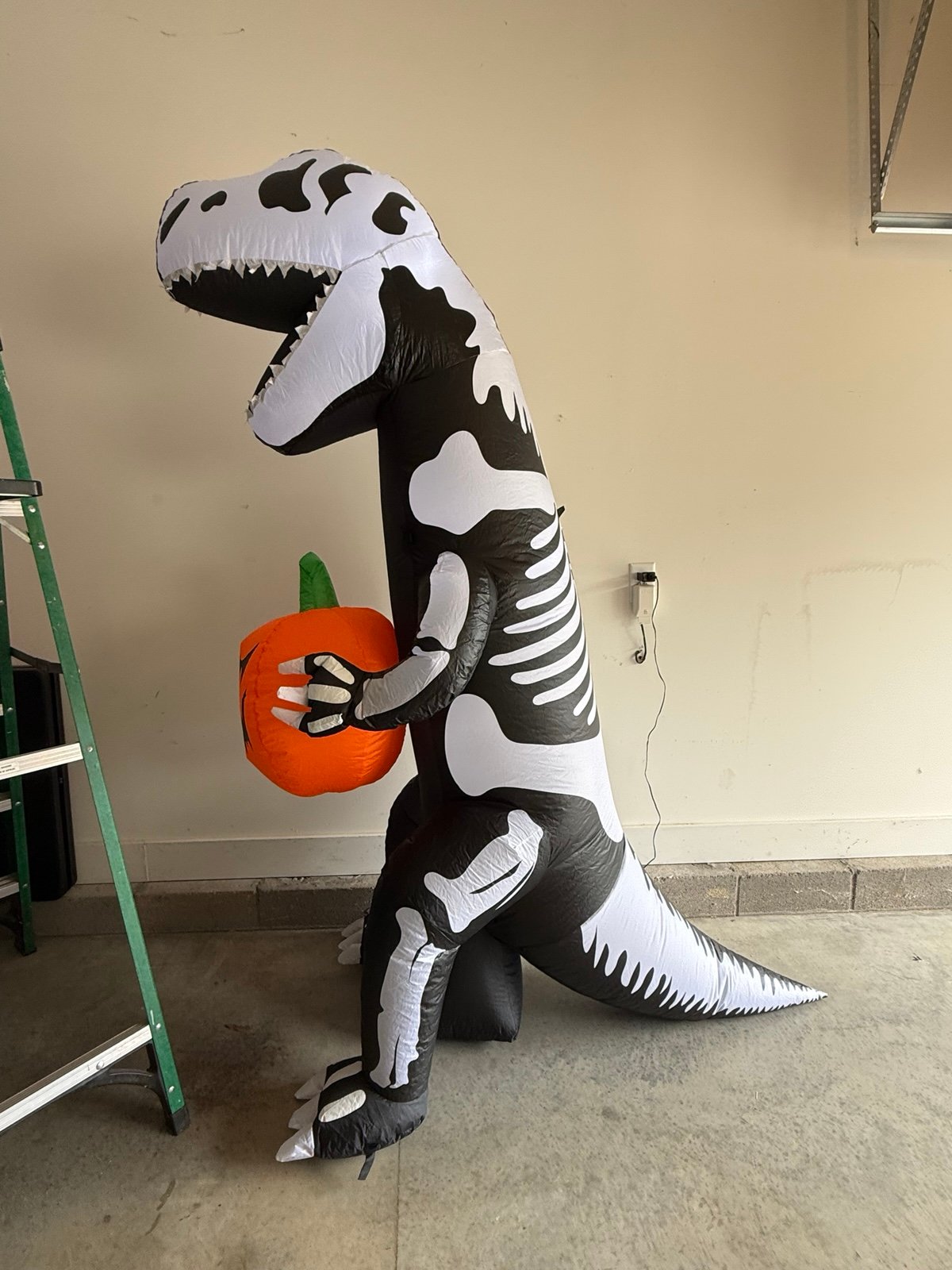 7 foot skeleton dinosaur holding pumpkin inflatable