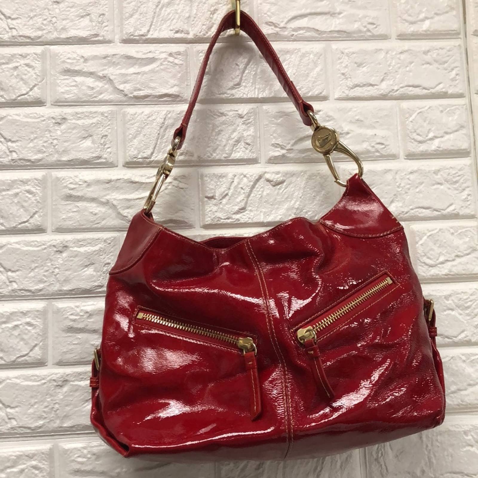Dooney & Bourke red patent shoulder bag with gold accents