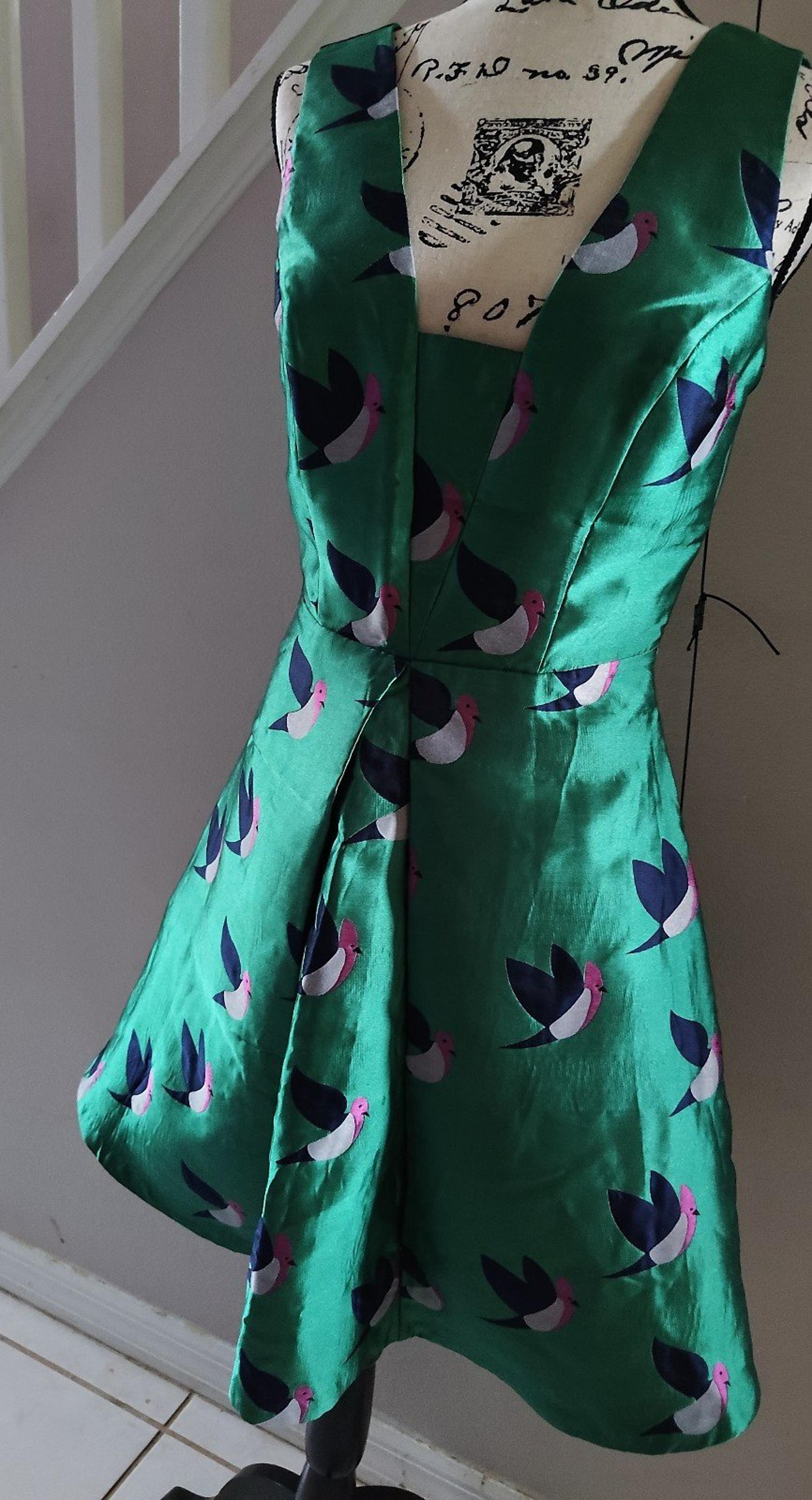 Delicate green cocktail dress with bird pattern from Eva Franco