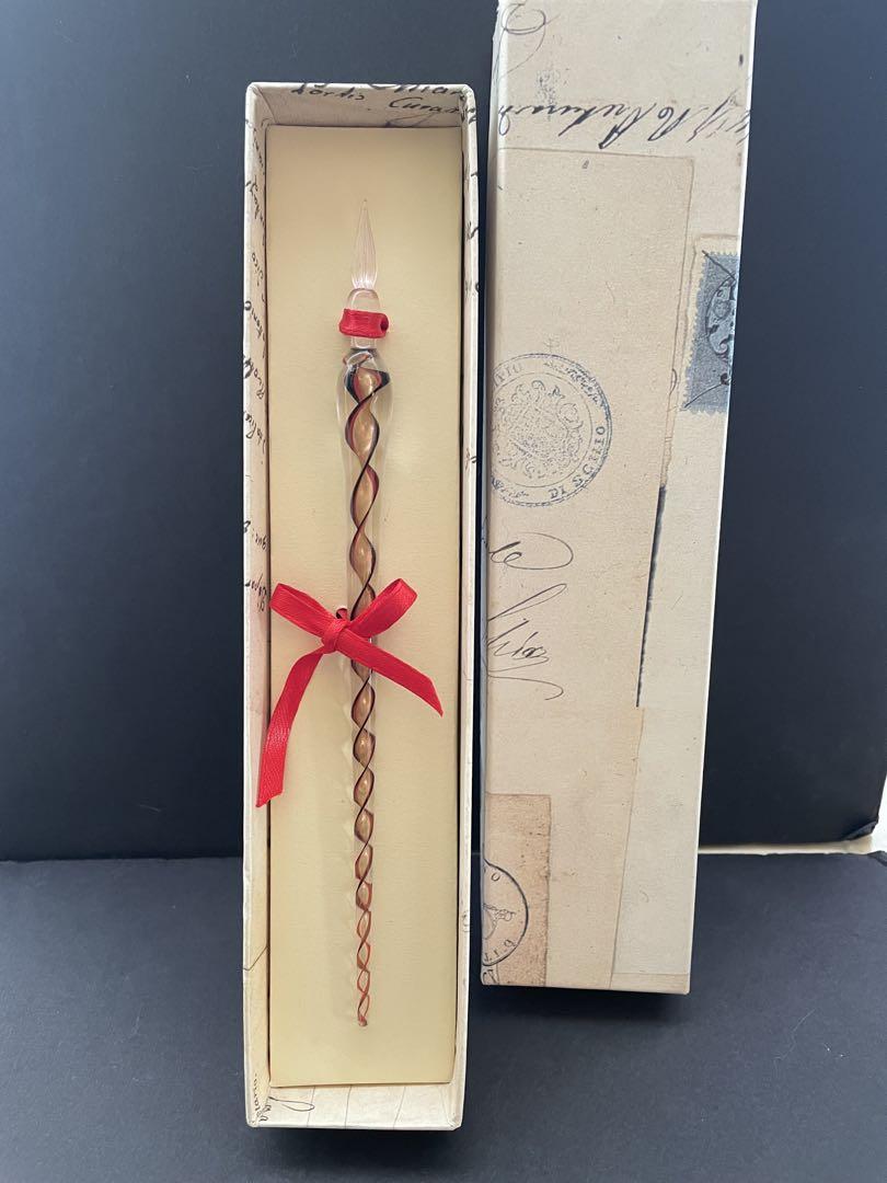 Venetian glass pen with a brown and red twist design.