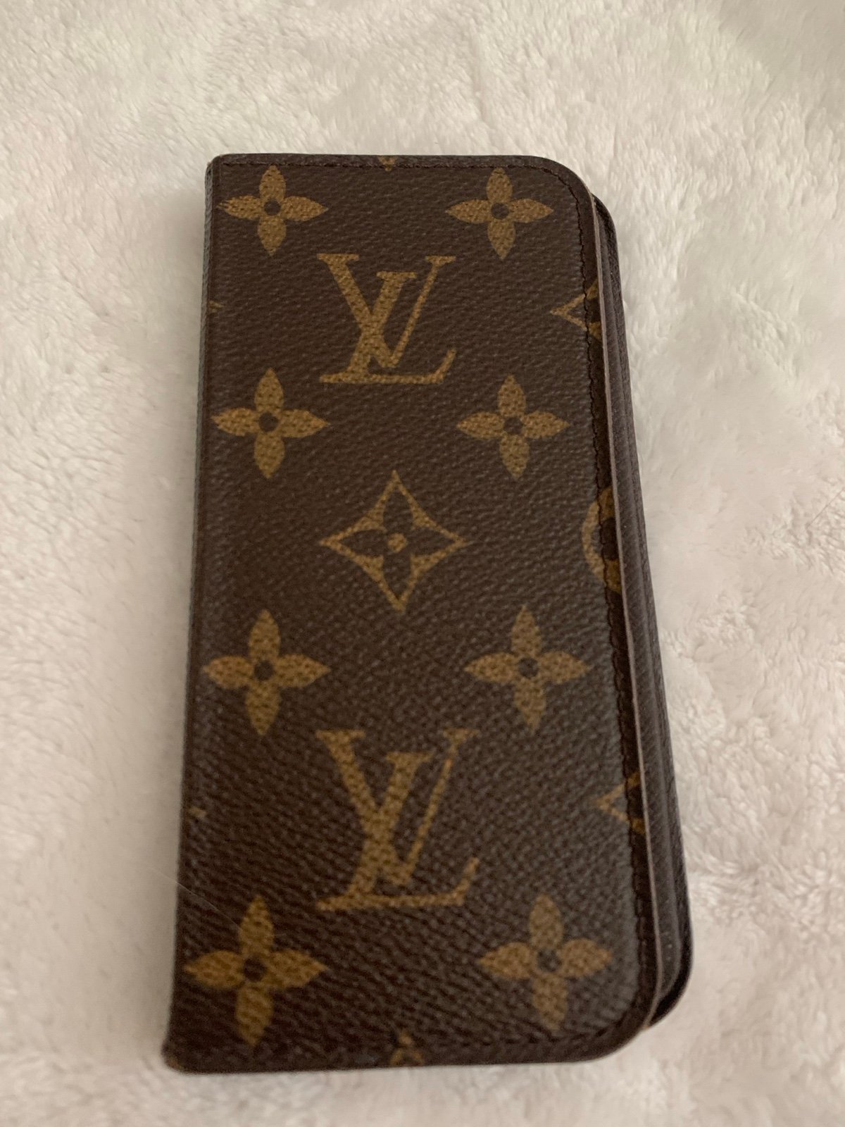 Elegant Louis Vuitton IPhone case with iconic monogram design. Features brown an