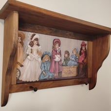 Vintage wood crafted wall shelf with pegs and a Victorian themed period print