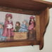 Vintage wood crafted wall shelf with pegs and a Victorian themed period print