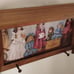 Vintage wood crafted wall shelf with pegs and a Victorian themed period print