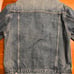 Denim blue jean jacket with button closure.