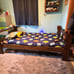 Twin size wooden bed with shelf on one side.