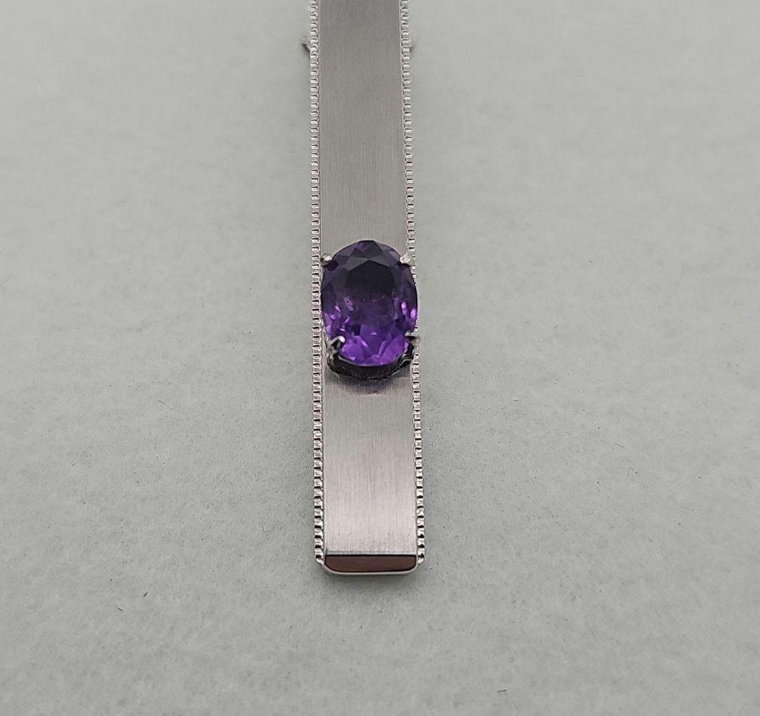 Tie pin with purple gemstone, silver hallmark.