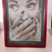 The image is a pencil sketch of a woman's face. She is looking at the viewer wit