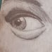 The image is a pencil sketch of a woman's face. She is looking at the viewer wit