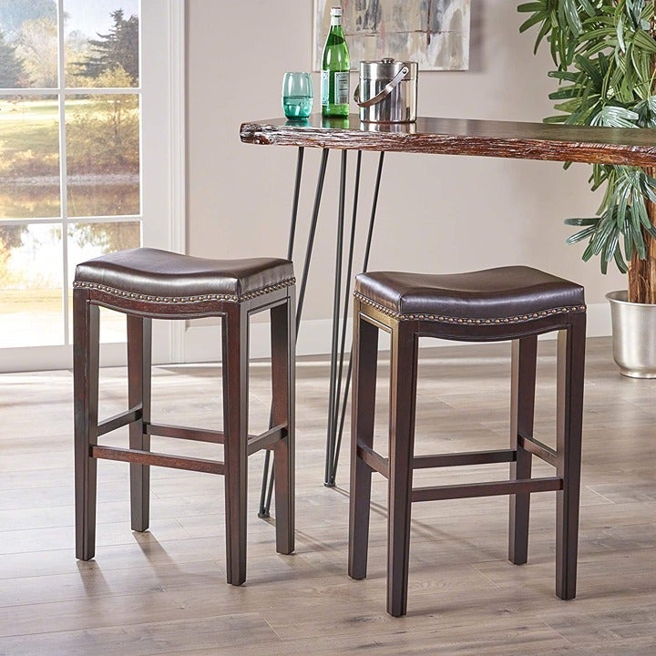 2 faux leather saddle barstools with nail head trim