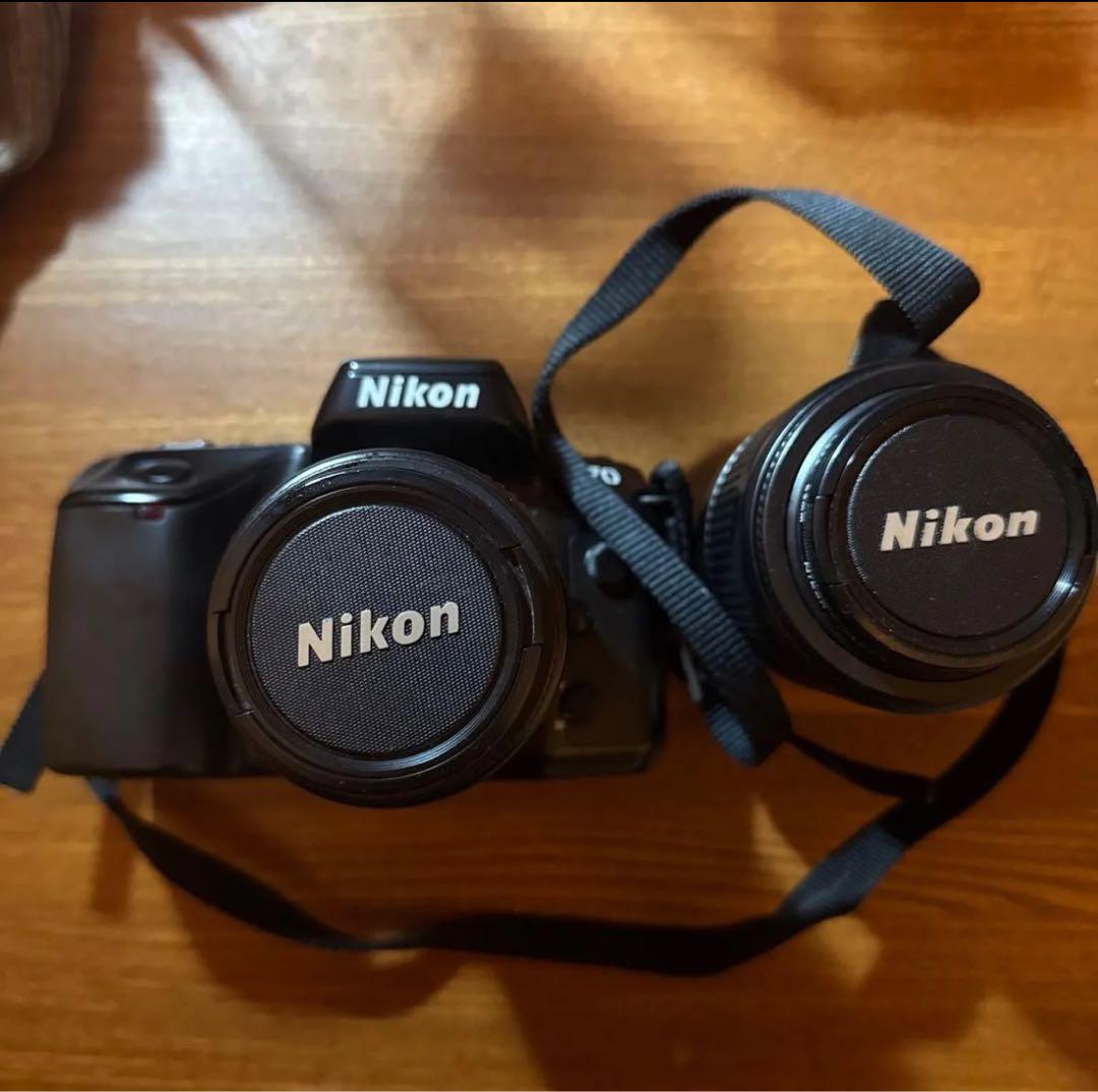 Nikon F70 SLR camera with two lenses.