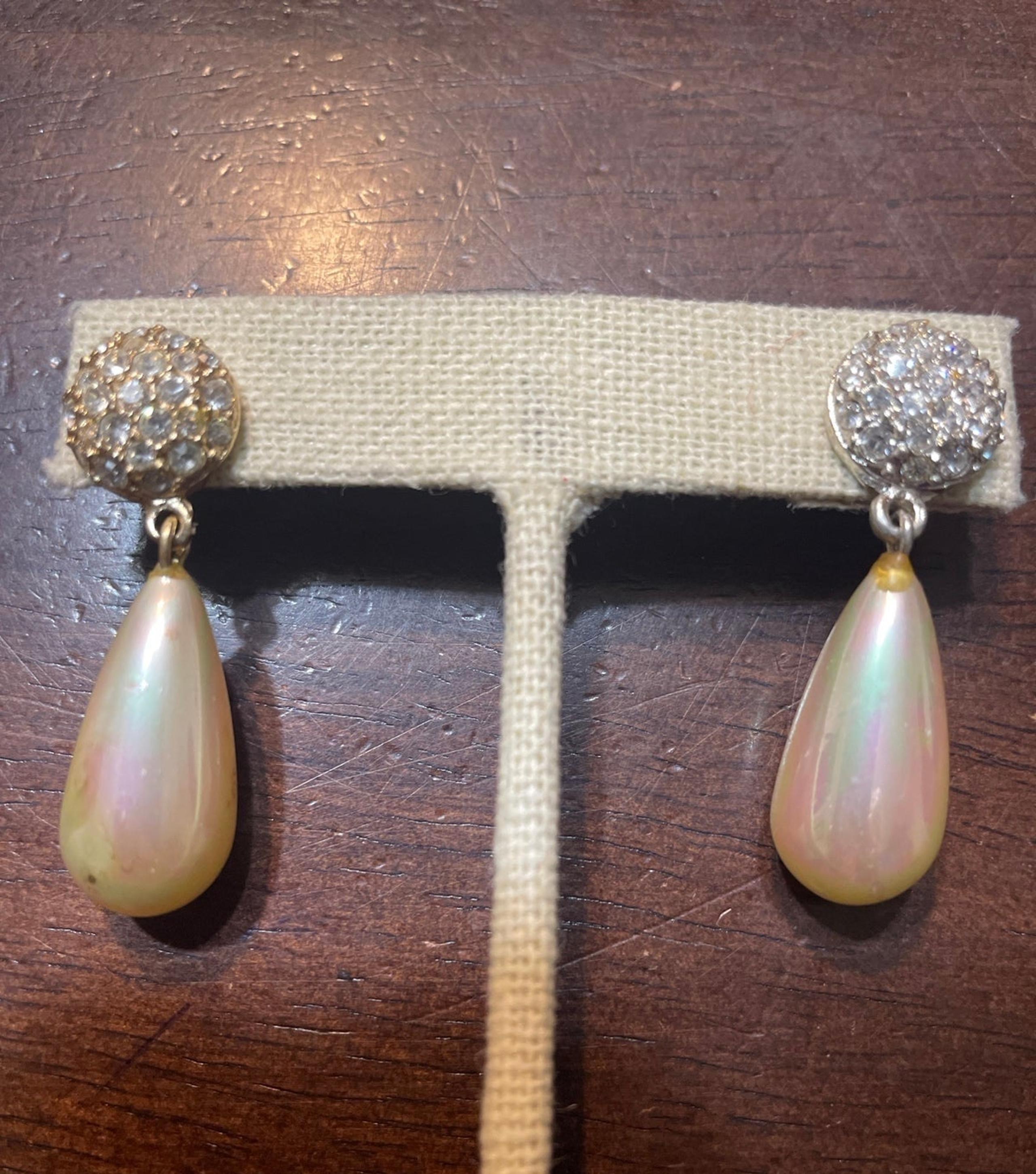 Large tear drop faux pearl hanging from diamente rhinestones disc.