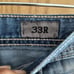 Distressed buckle jeans