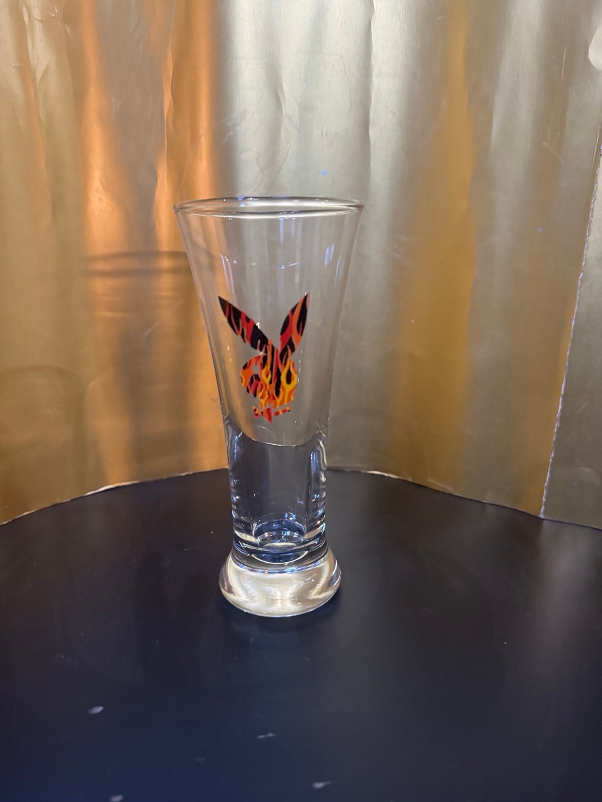 a vintage Playboy Bunny beer glass with a fire flame logo.