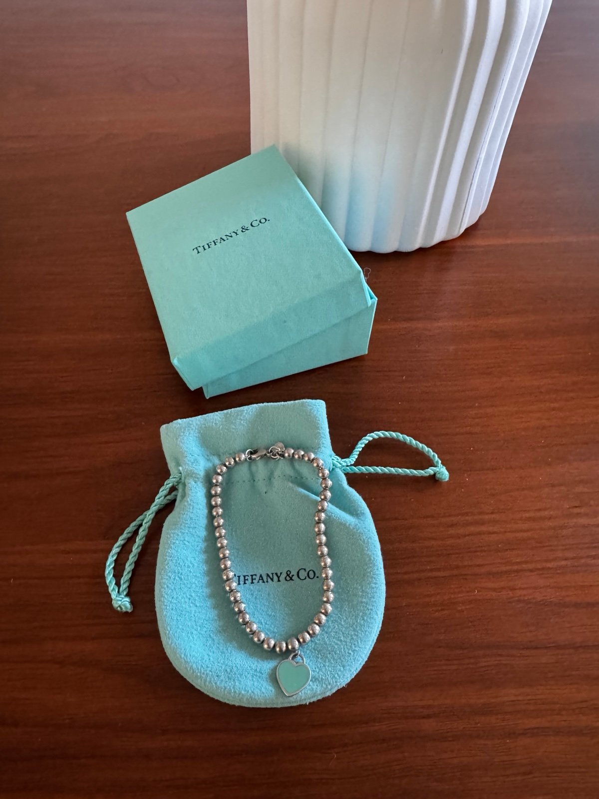 Return to Tiffany mini heart tag in sterling silver on a bead bracelet.