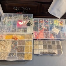 four organizers full of beads