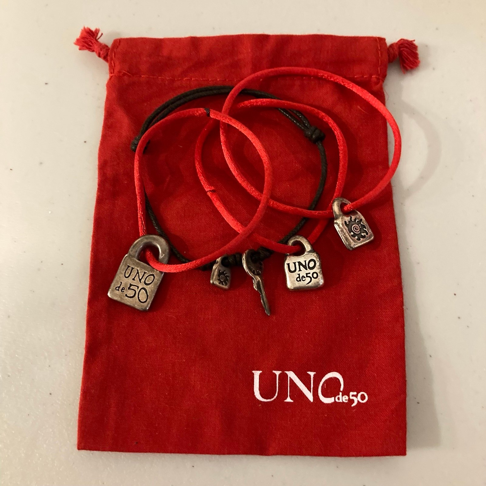 Uno de 50 Red Cord Bracelets w/charms + Brown Leather Bracelet w/charms + Pouch