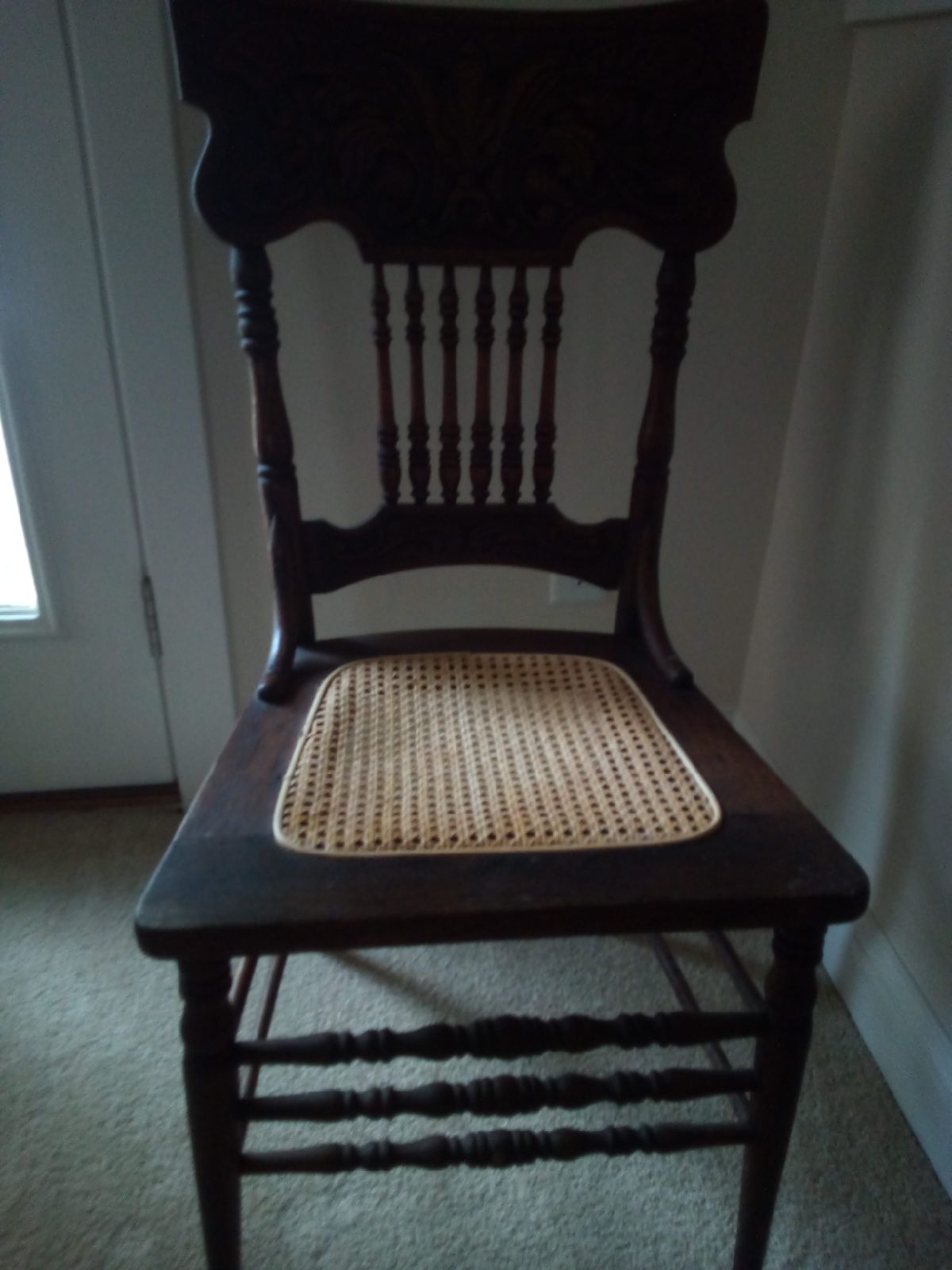 Antique press back chair with cane seat.