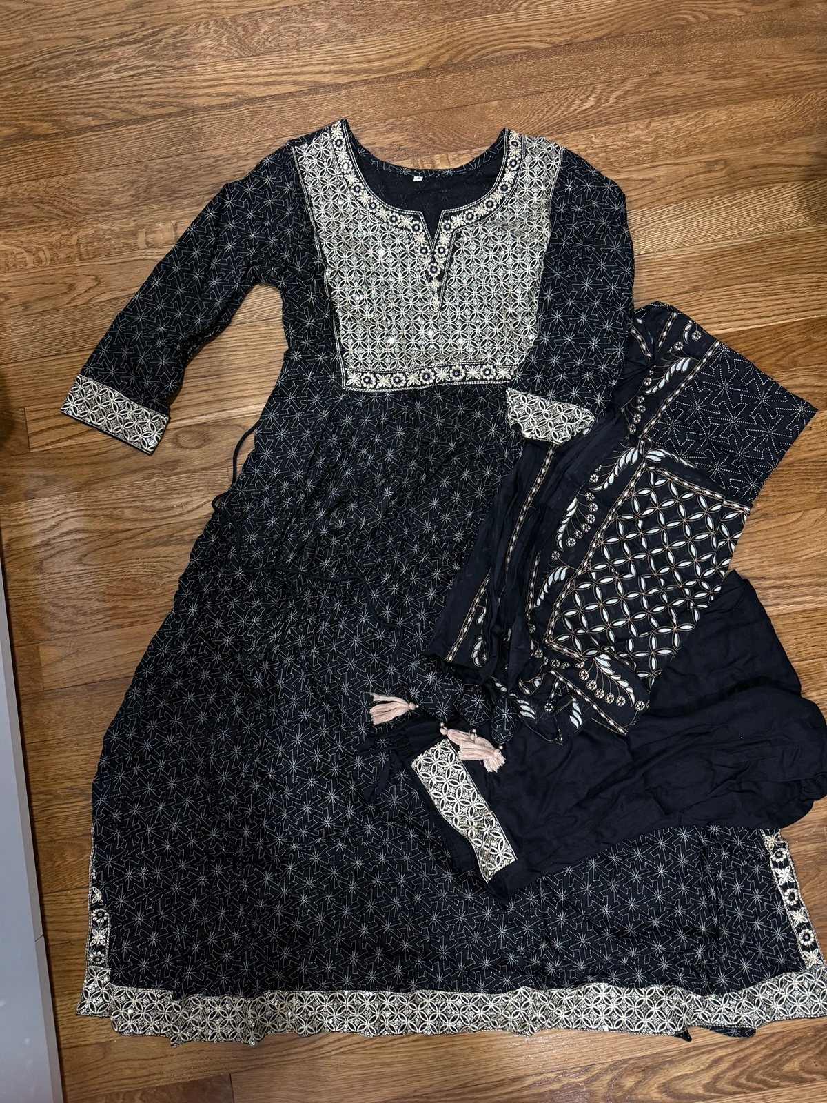 Elegant black and gold patterned dress with matching scarf and pants.