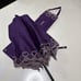 A Saint Laurent parasol with elegant purple and silver embroidery.