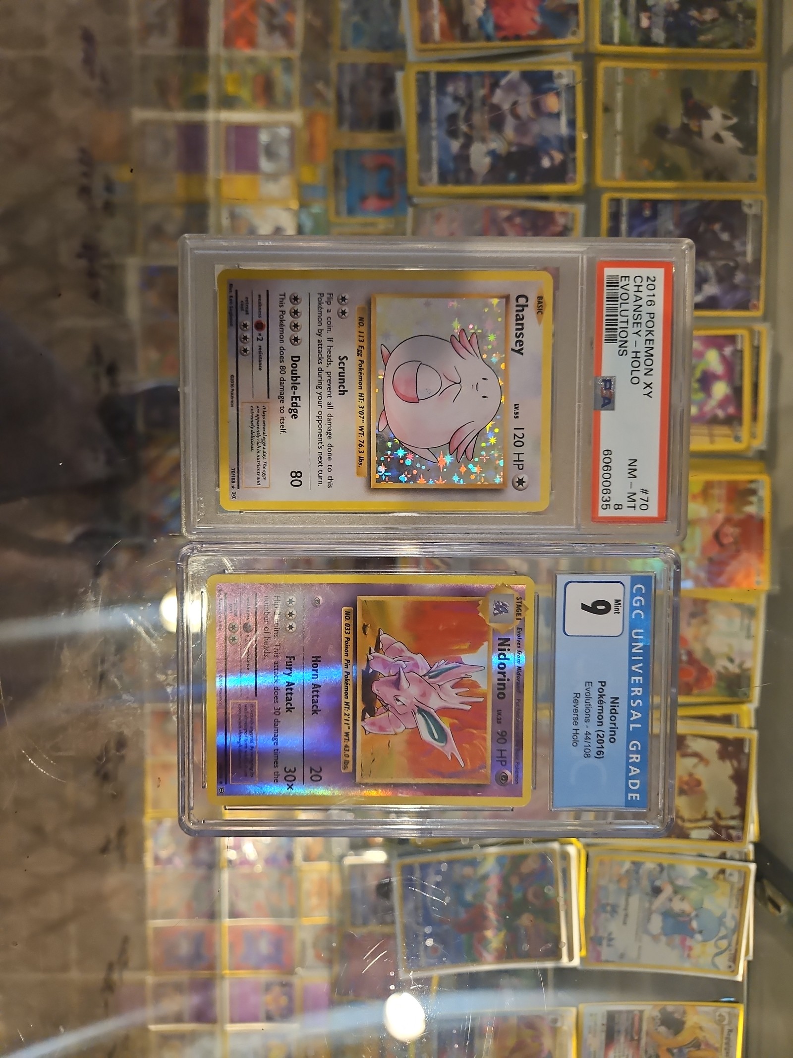 Two graded pokemon cards Chansey and Nidorino