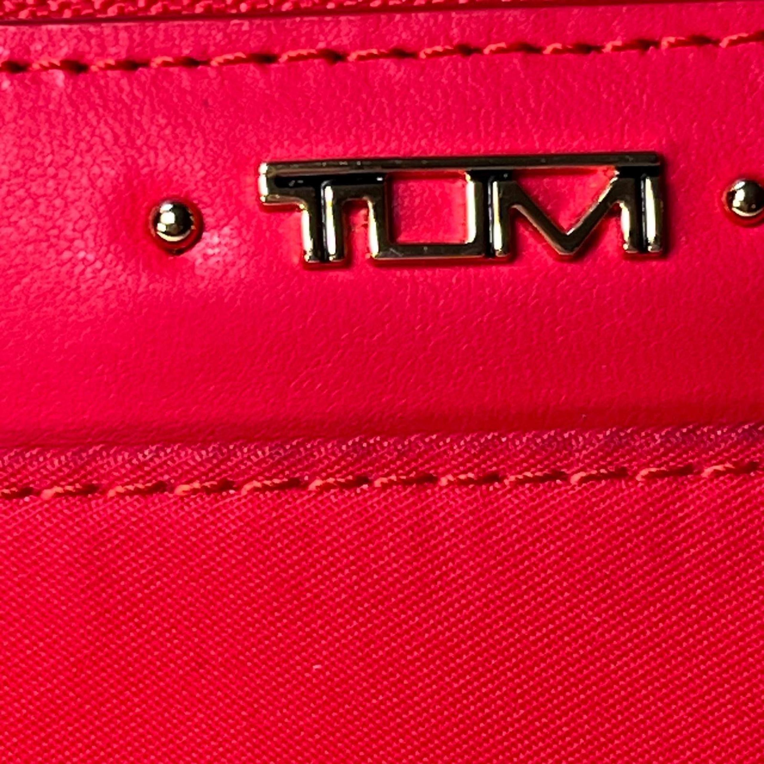 Tumi trifold red wallet with area for drivers license, cards and money.