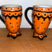 Rare Rae Dunn M Magenta set of 2 footed orange black polka dot mugs footed. Ve