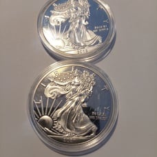 Two one ounce silver clad collectors souvenir coins in plastic capsules