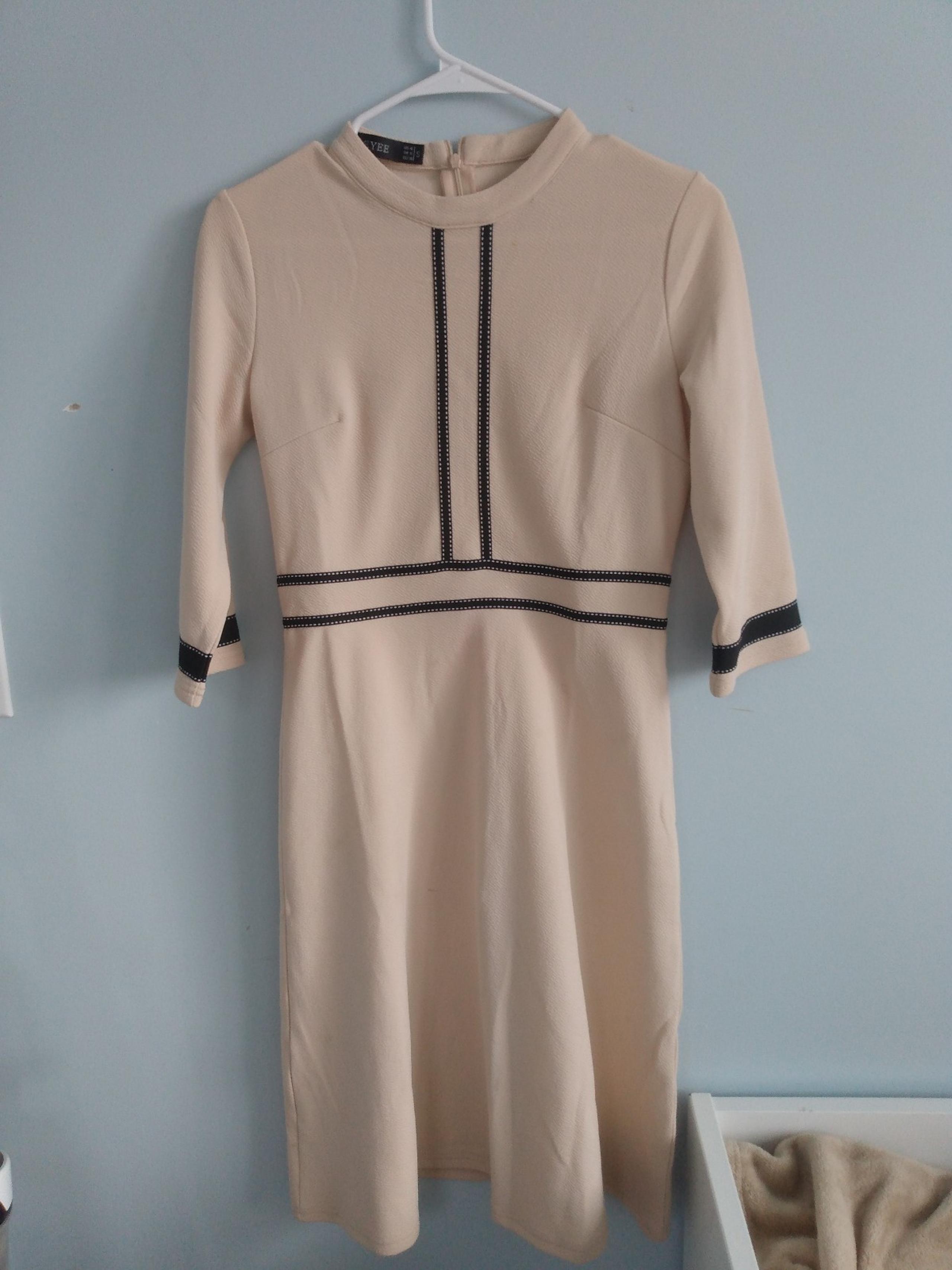 dress with a the colors beige and black and has a zipper.