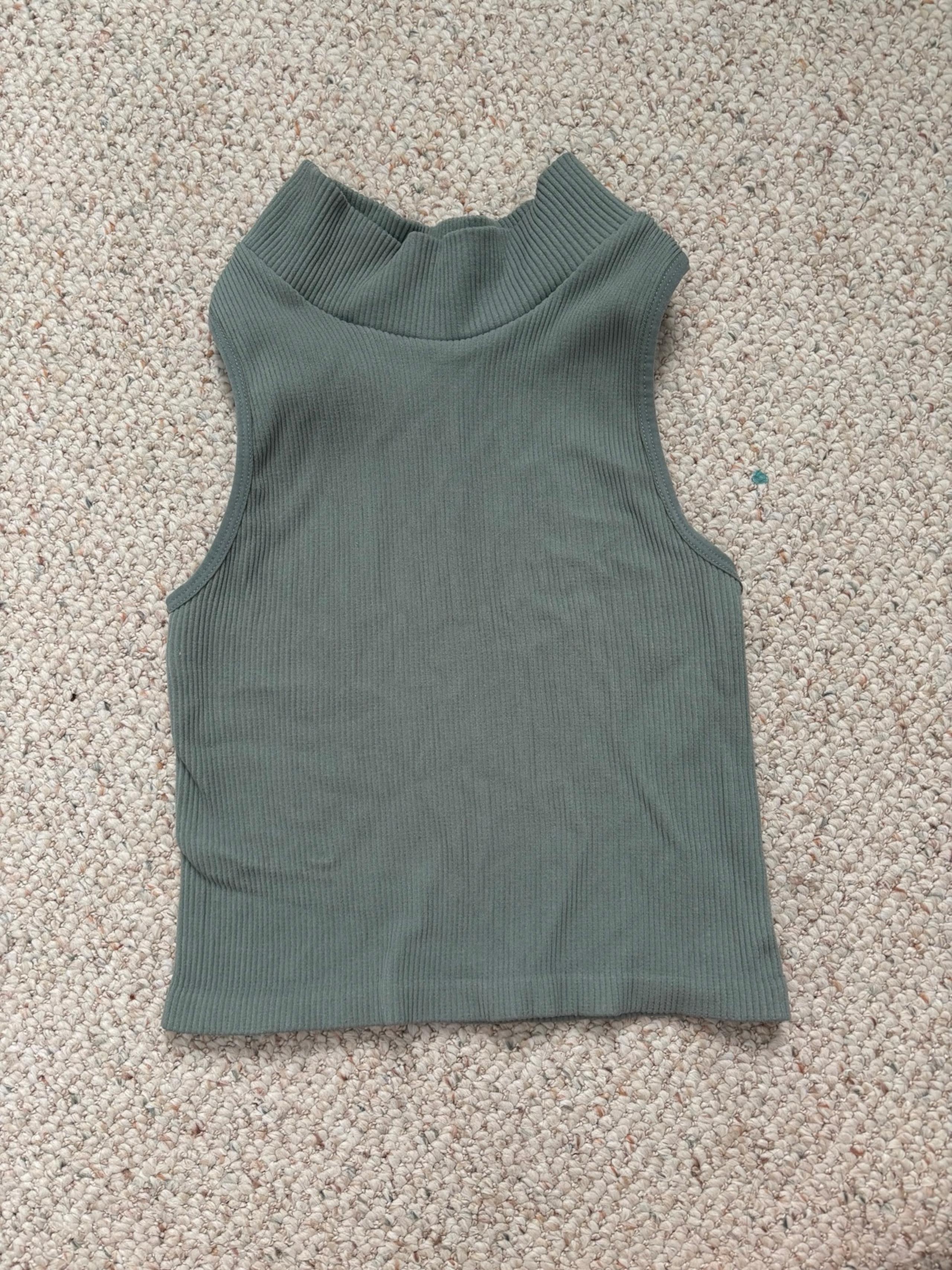 Green ribbed sleeveless turtleneck crop top