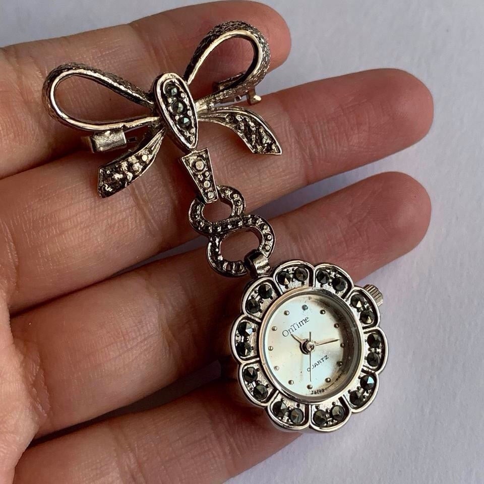 Silver tone brooch watch with rhinestone bow